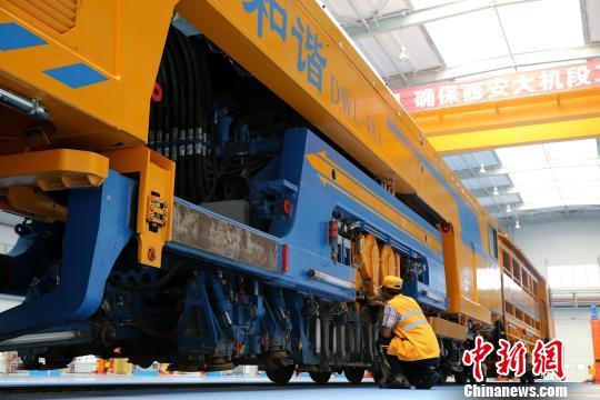 圖為工人正在清理大型養(yǎng)路機(jī)械。　張遠(yuǎn) 攝